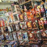 Étalage de figurines d’anime en magasin spécialisé, présentant différentes gammes de figures de collection sous vitrine.