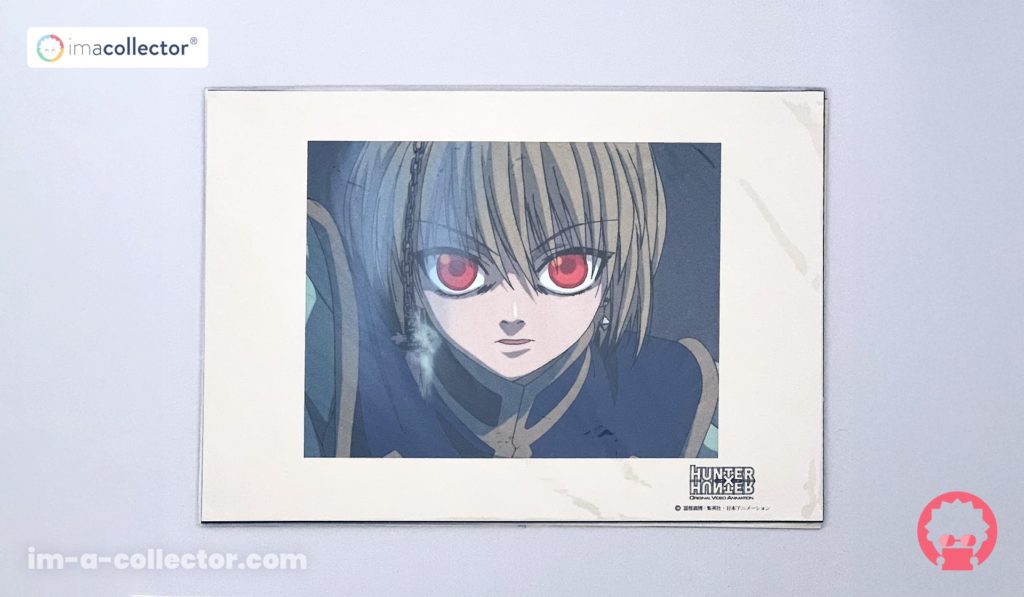 Rilezu officiel de Kurapika au regard déterminé, avec chaîne visible au premier plan, issu de l’anime Hunter × Hunter de 1999.