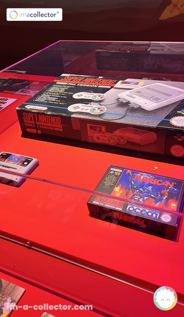 Console Super Nintendo PAL exposée sous vitrine avec le jeu Super Turrican dans Video Games & Music.